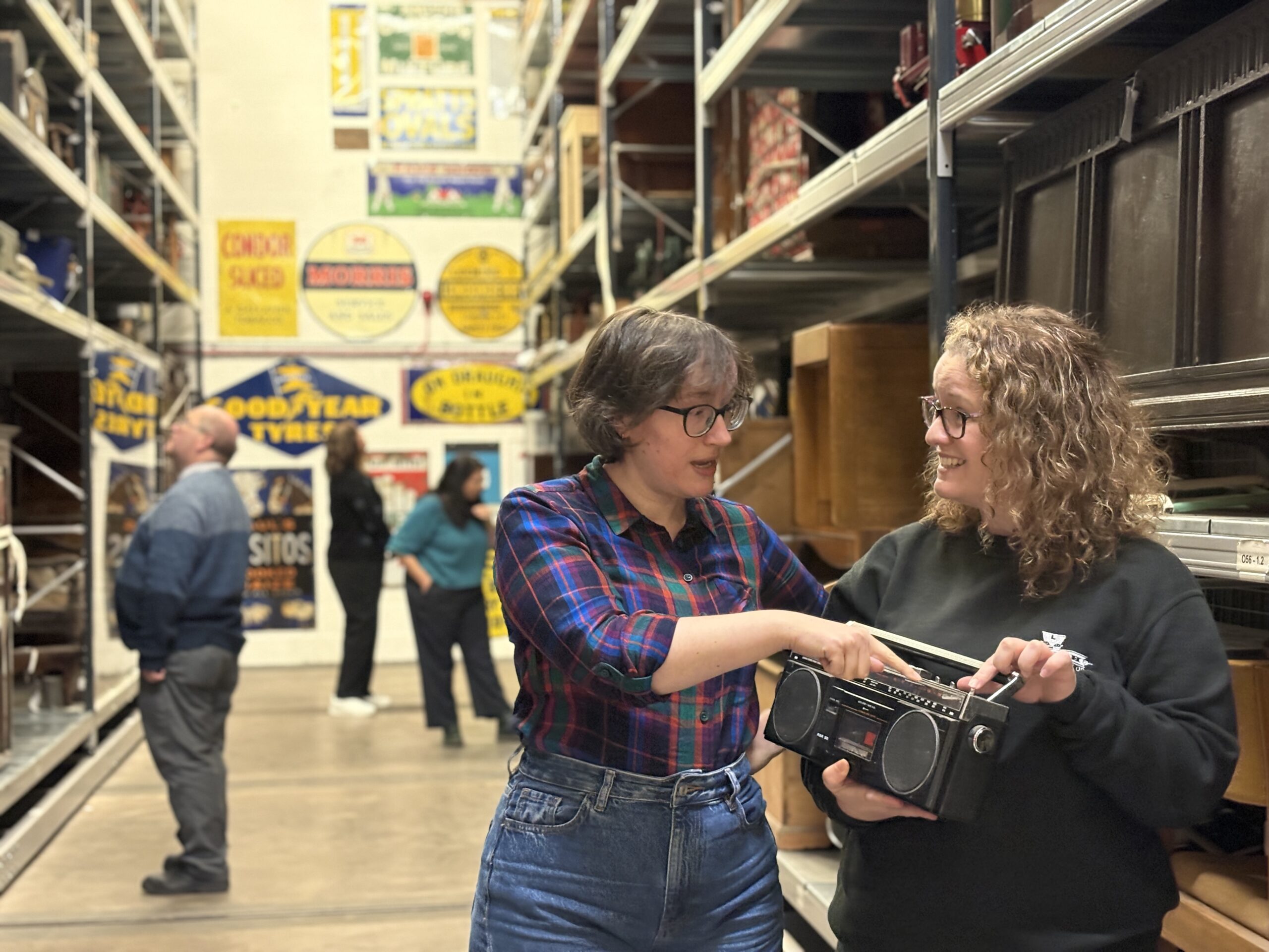 Two people holding an old radio
