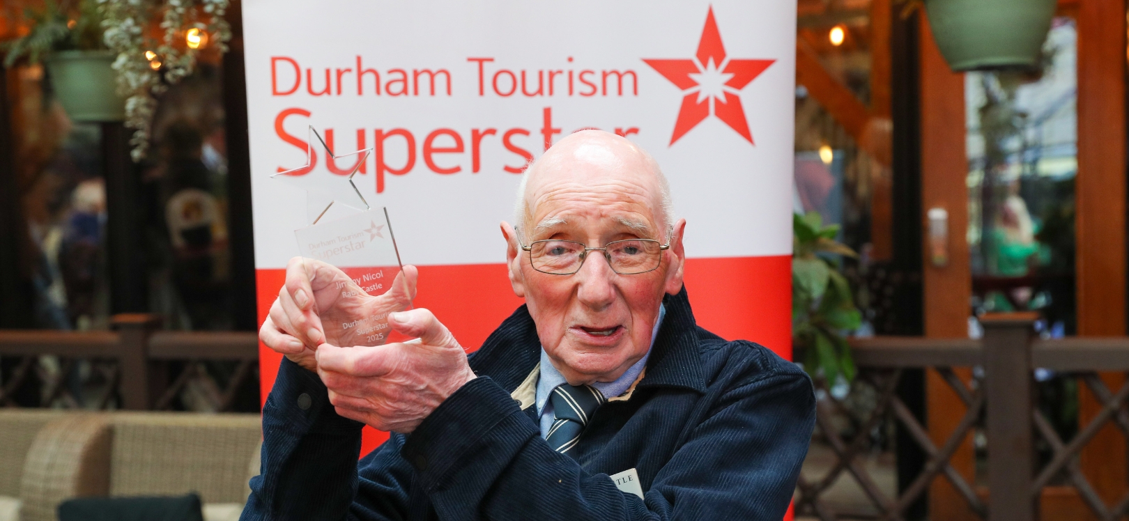Jimmy Durham's Tourism Superstar winner holding a trophy