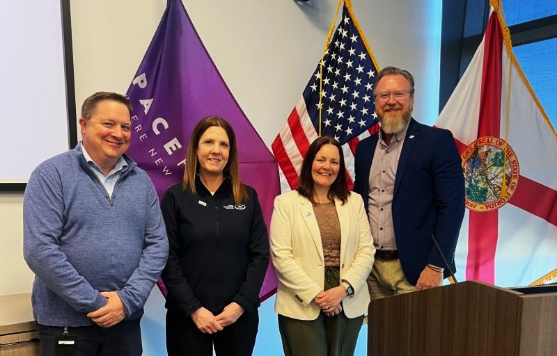 Four people stood in front of flags